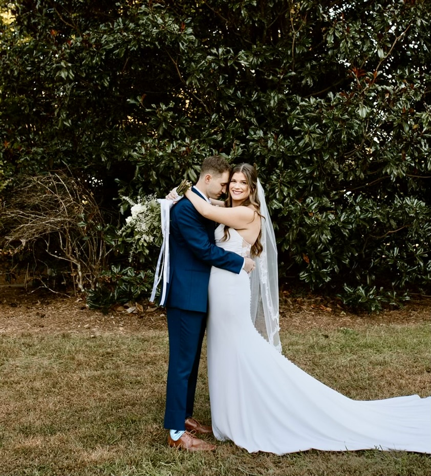 Brooke and Sean on their wedding day, embracing in a garden