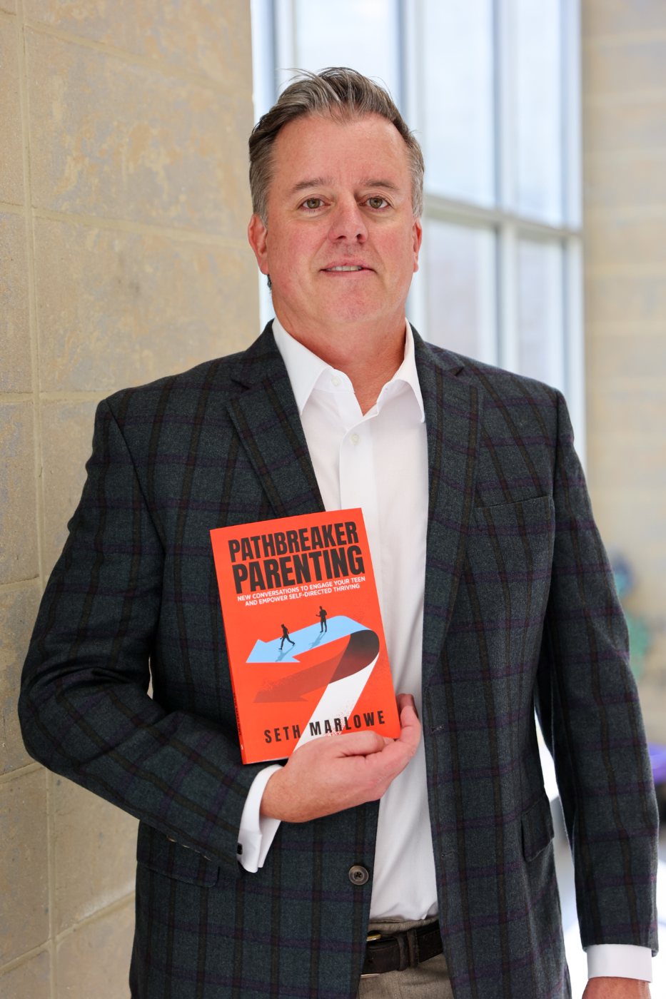 Seth Marlowe, author of Pathbreaker Parenting, holding the book